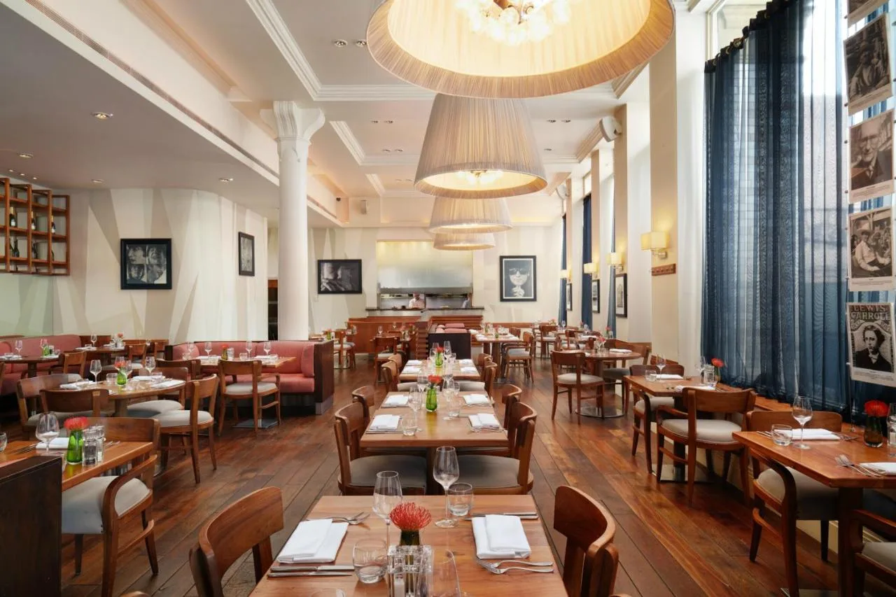 a restaurant with wooden tables and chairs and a dining room at Hard Days Night Hotel Liverpool in Liverpool