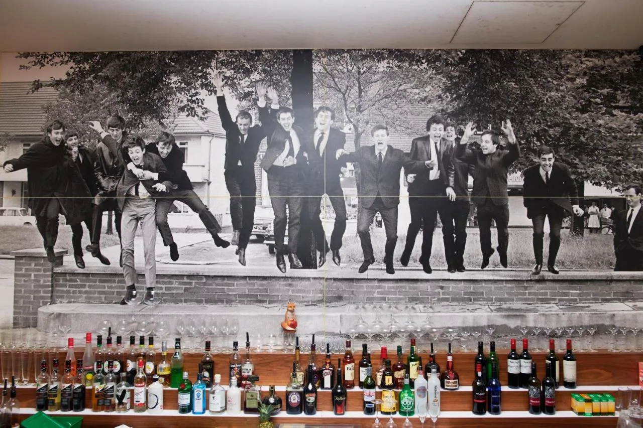a group of people jumping in front of a mural at Hard Days Night Hotel Liverpool in Liverpool