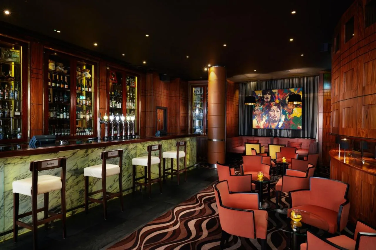 a restaurant with red chairs and a bar at Hard Days Night Hotel Liverpool in Liverpool